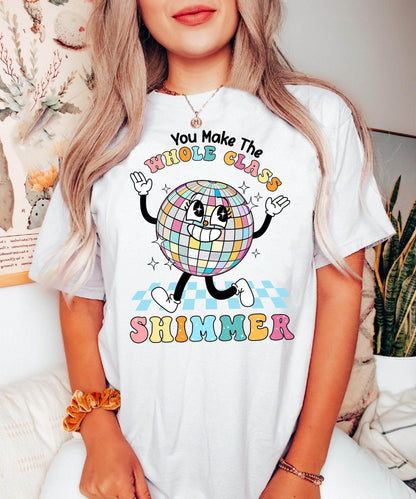 The words WHOLE CLASS SHIMMER arc over a sparkling disco ball character, whose hands and feet are playfully positioned to add movement and energy, celebrating the lively spirit of a harmonious class.