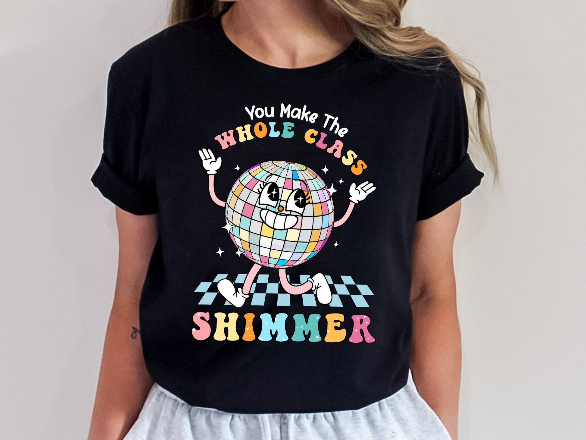 Festive and animated, the design features a disco ball with a whimsical expression, paired with the words WHOLE CLASS SHIMMER in a rainbow of pastel shades, symbolizing the vibrancy of classroom life.