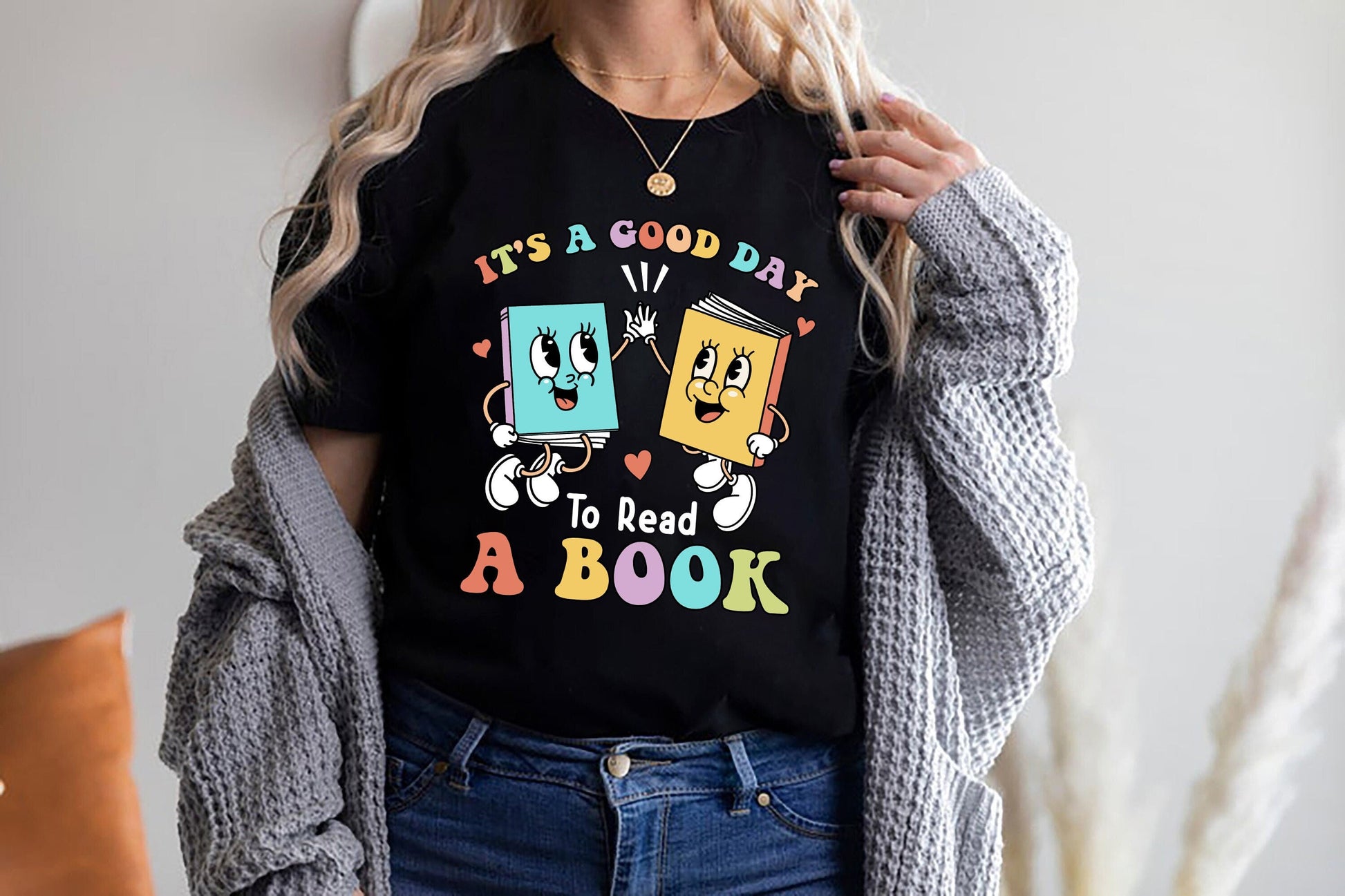 Animated and cheerful, the illustration features a pair of books with endearing faces and outstretched arms, coming together in a friendly high-five, set against a backdrop of a friendly message promoting reading, soft, multi-colored letters.