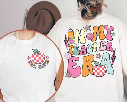 Bold, cartoonish letters spell out IN MY TEACHER ERA, filled with a kaleidoscope of pastels and accented with fun school symbols like a bright pink pencil and a playful, patterned apple.