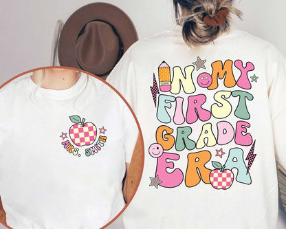 A cheerful design showcasing the words In my first grade era in bright bold letters The design is decorated with cute elements such as a pencil apple stars and smiley faces for a joyful and upbeat feel