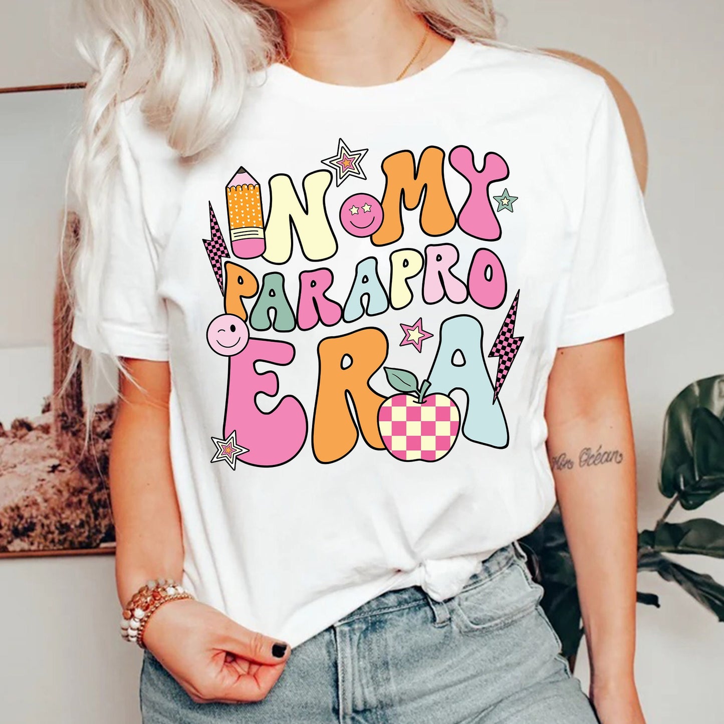 The graphic embodies the spirit of paraprofessional work, featuring IN MY PARA ERA in bold, eye-catching characters, interspersed with lively icons of learning and creativity, such as a joyful paintbrush, an engaging palette