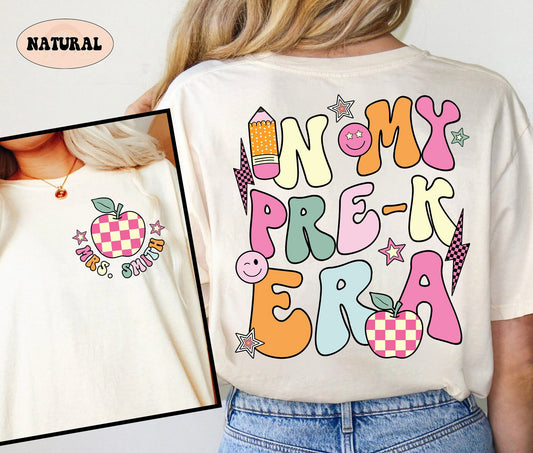 The design is a vibrant celebration of early childhood education, with the phrase IN MY PREK TEACHER ERA presented in bold, colorful letters, accompanied by cheerful symbols including a playful paintbrush, a palette, and a checkered apple