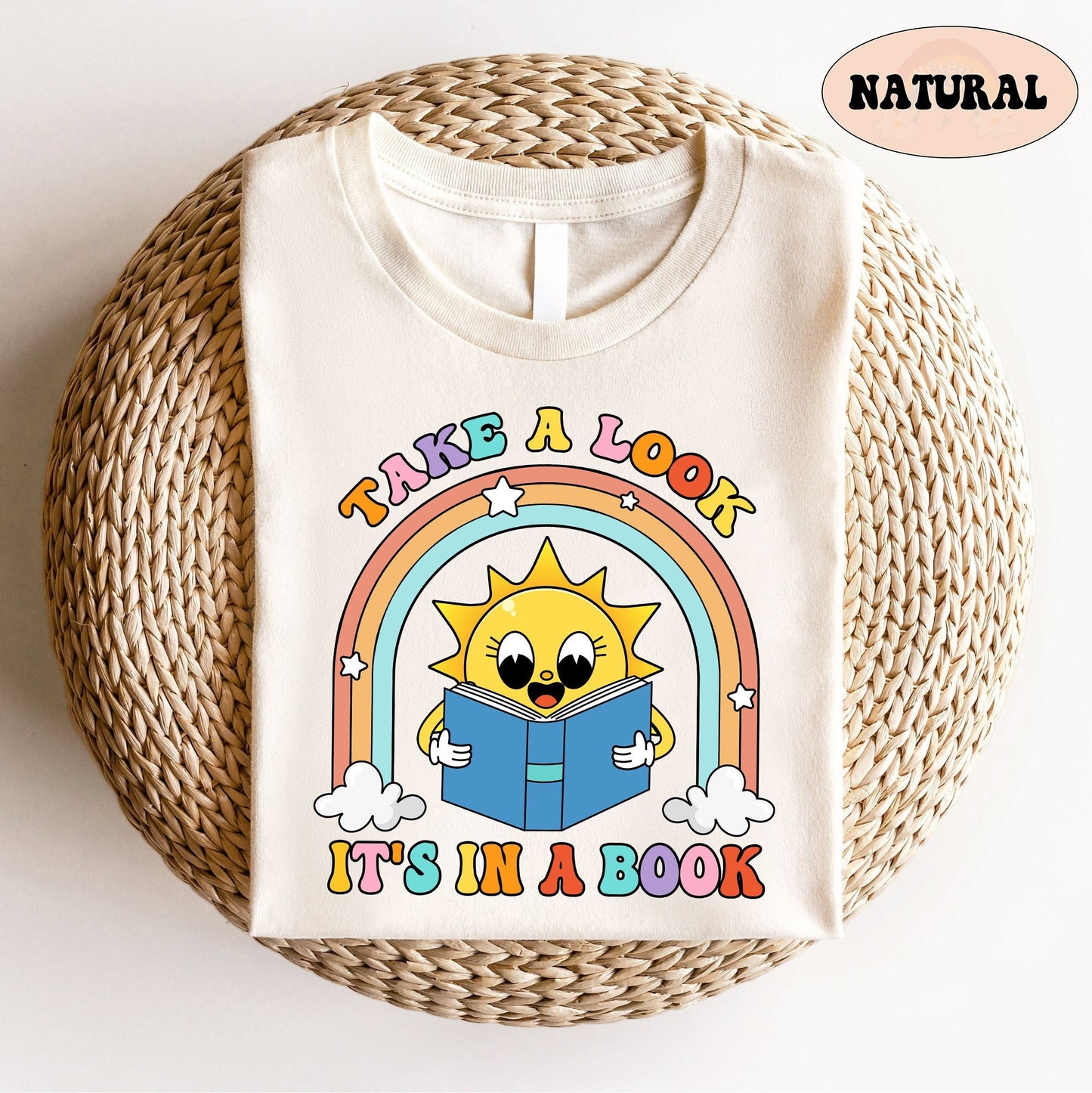A playful graphic with a happy sun holding a book beneath a rainbow The message take a look it&#39;s in a book is written in bright colors making the design both educational and charming