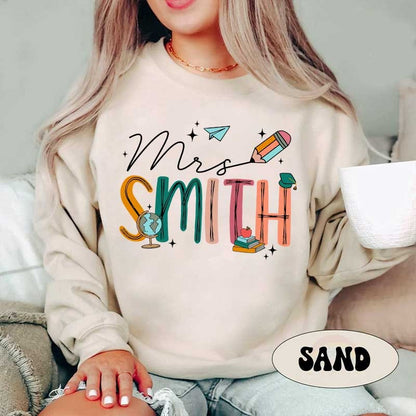 A bright design for Mrs. Smith where each letter is crafted from educational items like a globe, pencil, and books accented with a paper airplane and graduation cap.