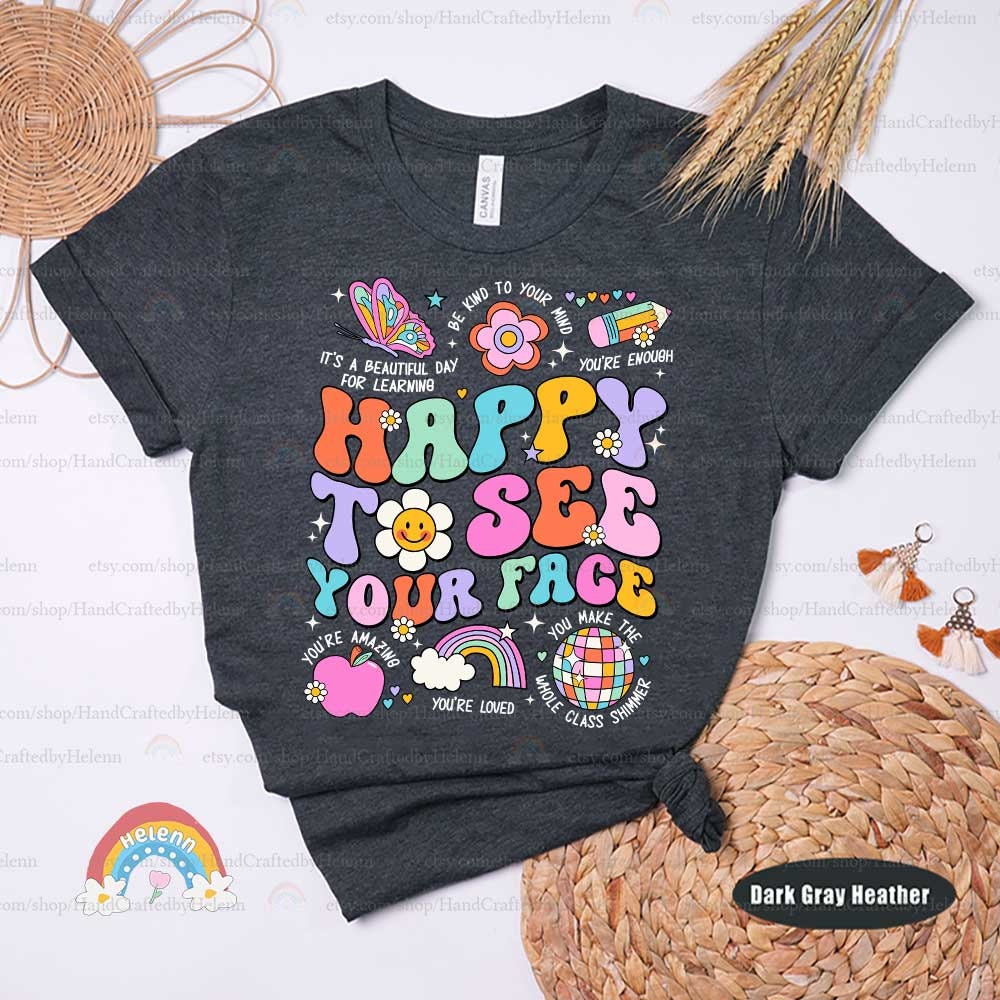 The phrase HAPPY TO SEE YOUR FACE pops in a fun array of vibrant colors, accompanied by delightful illustrations like a smiling flower face, a whimsical rainbow, and a colorful butterfly, evoking a sense of joyful greeting and creativity.