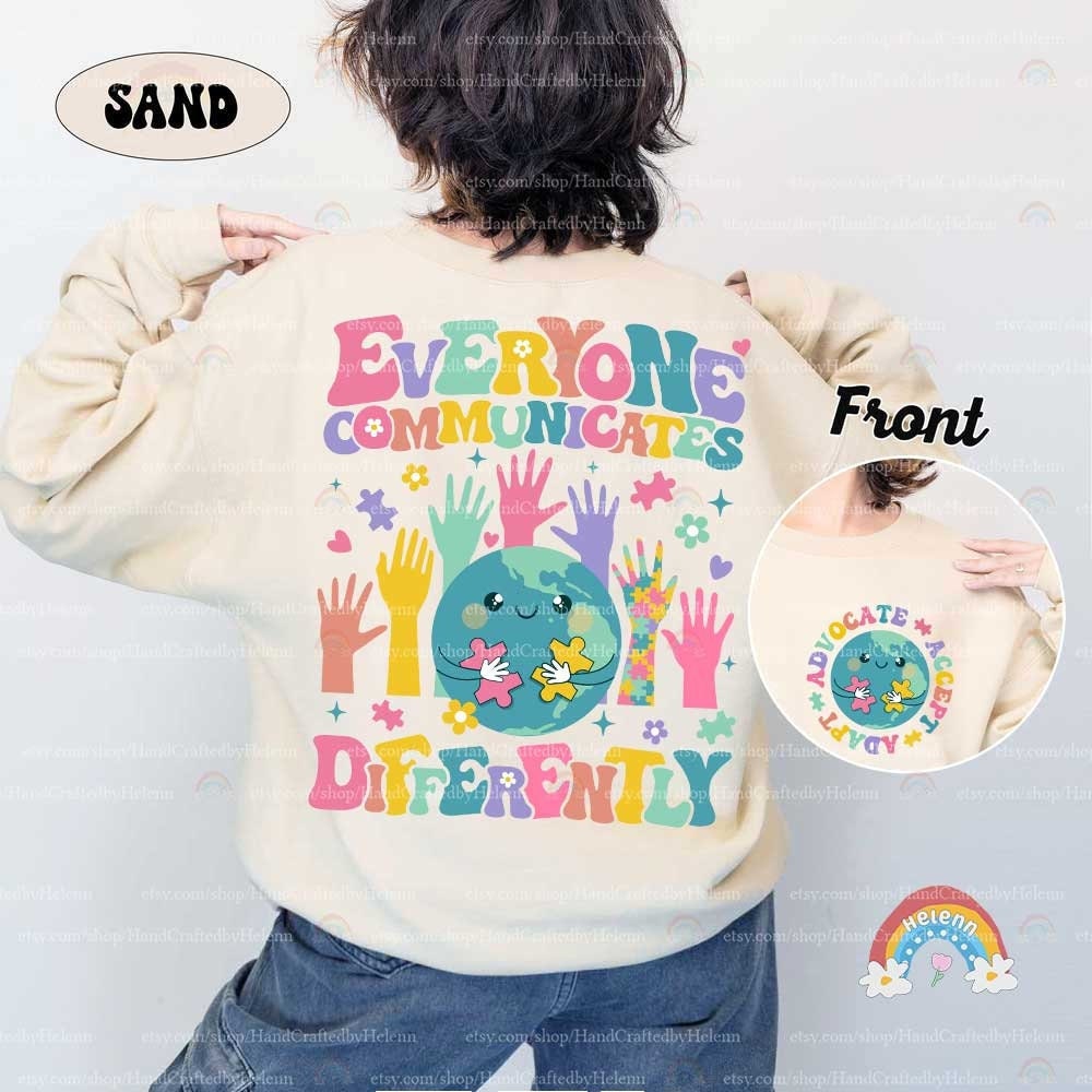 A tribute to the varied ways people connect, featuring a globe with a tender smile, pieced together by puzzle elements, all above the gentle reminder EVERYONE COMMUNICATES DIFFERENTLY in cloud-like colorful text.