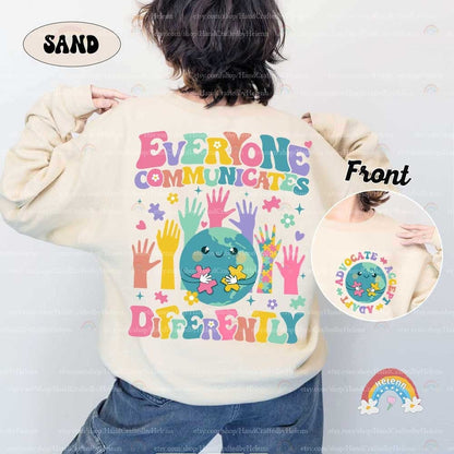 A tribute to the varied ways people connect, featuring a globe with a tender smile, pieced together by puzzle elements, all above the gentle reminder EVERYONE COMMUNICATES DIFFERENTLY in cloud-like colorful text.