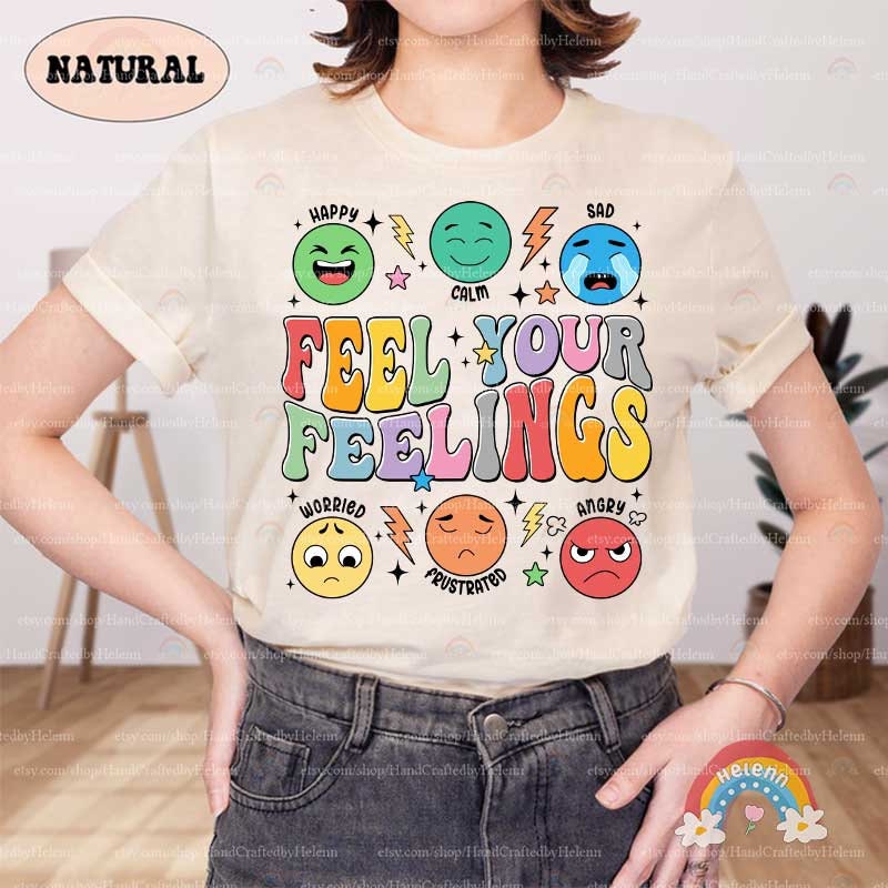 The playful and meaningful artwork portrays the message FEEL YOUR FEELINGS in cheerful, multi-toned letters, teamed with animated emoticon faces that exhibit a spectrum of human emotions, all sprinkled with fun stars and electric bolts.