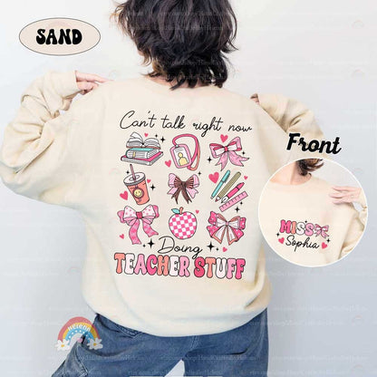 The words TEACHER STUFF are emblazoned in soft pink beneath a delightful array of teaching tools like books, writing instruments, and decorative bows, signifying the joy and care that goes into teaching.