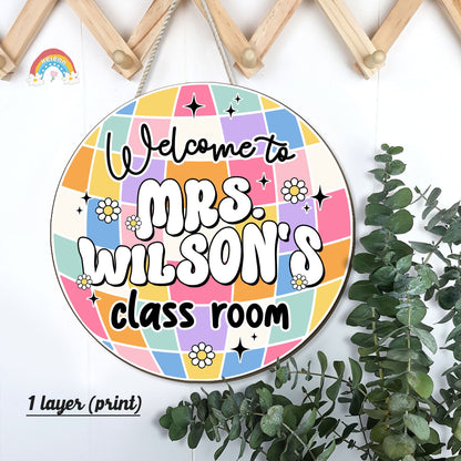 Bright and inviting door sign for Mrs. Wilson’s classroom, decorated with a multicolored geometric pattern, small flowers, and playful stars.