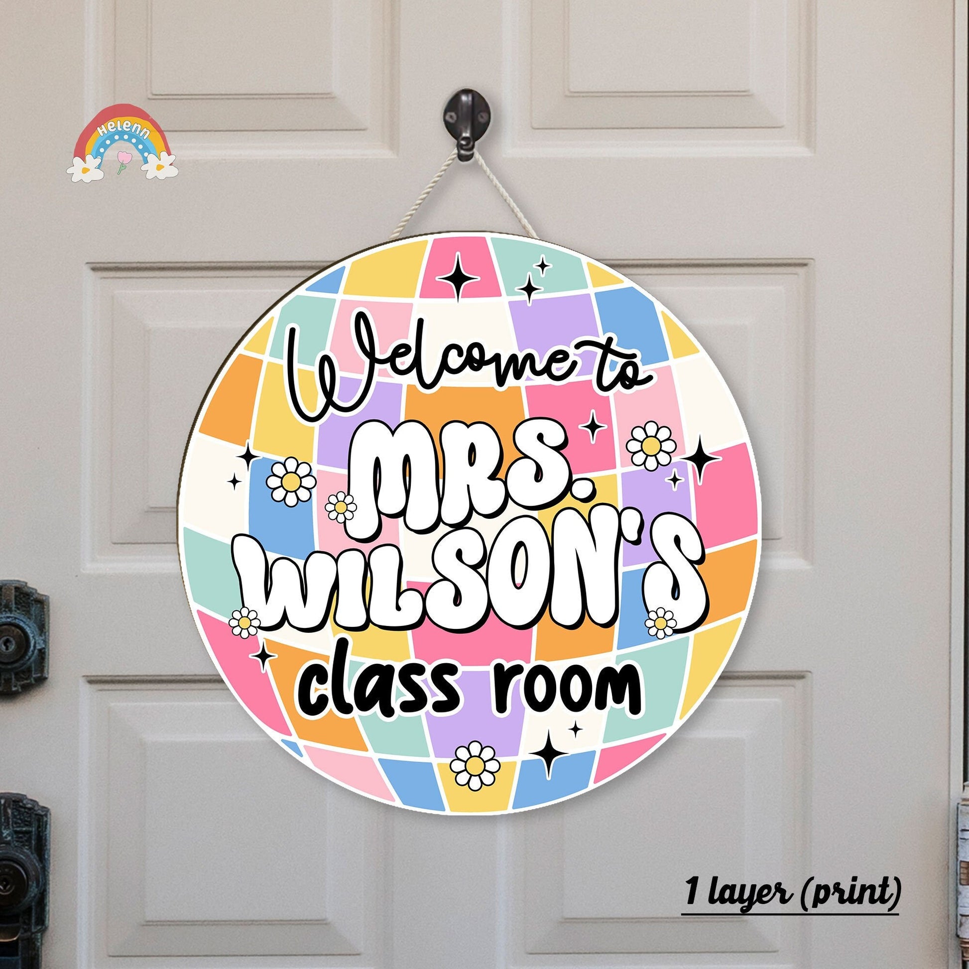 Circular classroom welcome sign for Mrs. Wilson featuring a colorful patchwork design with stars, flowers, and vibrant lettering on a door background.