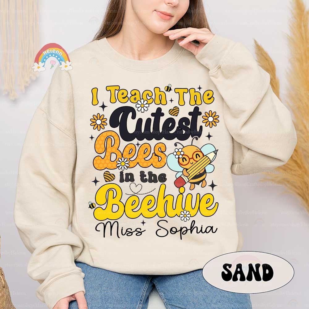 A playful and charming design featuring bold yellow text that reads I Teach the Cutest Bees in the Beehive, accompanied by a cheerful bee character playing a violin.