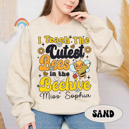 A playful and charming design featuring bold yellow text that reads I Teach the Cutest Bees in the Beehive, accompanied by a cheerful bee character playing a violin.