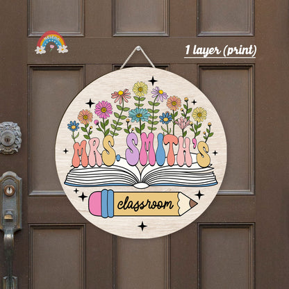 This decorative sign serves as a beautiful classroom identifier for Mrs. Smith, featuring a creative 3D effect with floral illustrations and book motifs, suggesting a lively and engaging learning space.