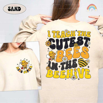 A playful and charming design featuring bold yellow text that reads I Teach the Cutest Bees in the Beehive, accompanied by a cheerful bee character playing a violin.