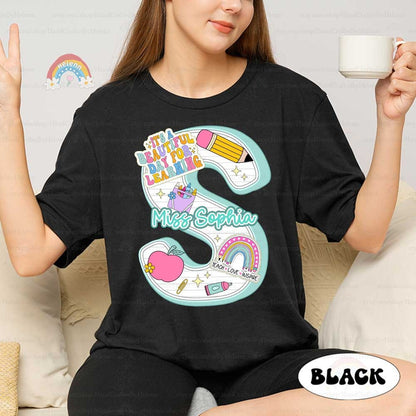 A charming design featuring the phrase It&#39;s a beautiful day for learning in playful lettering around a flowing ribbon, complemented by a cheerful array of educational icons like a pencil, apple, and rainbow.