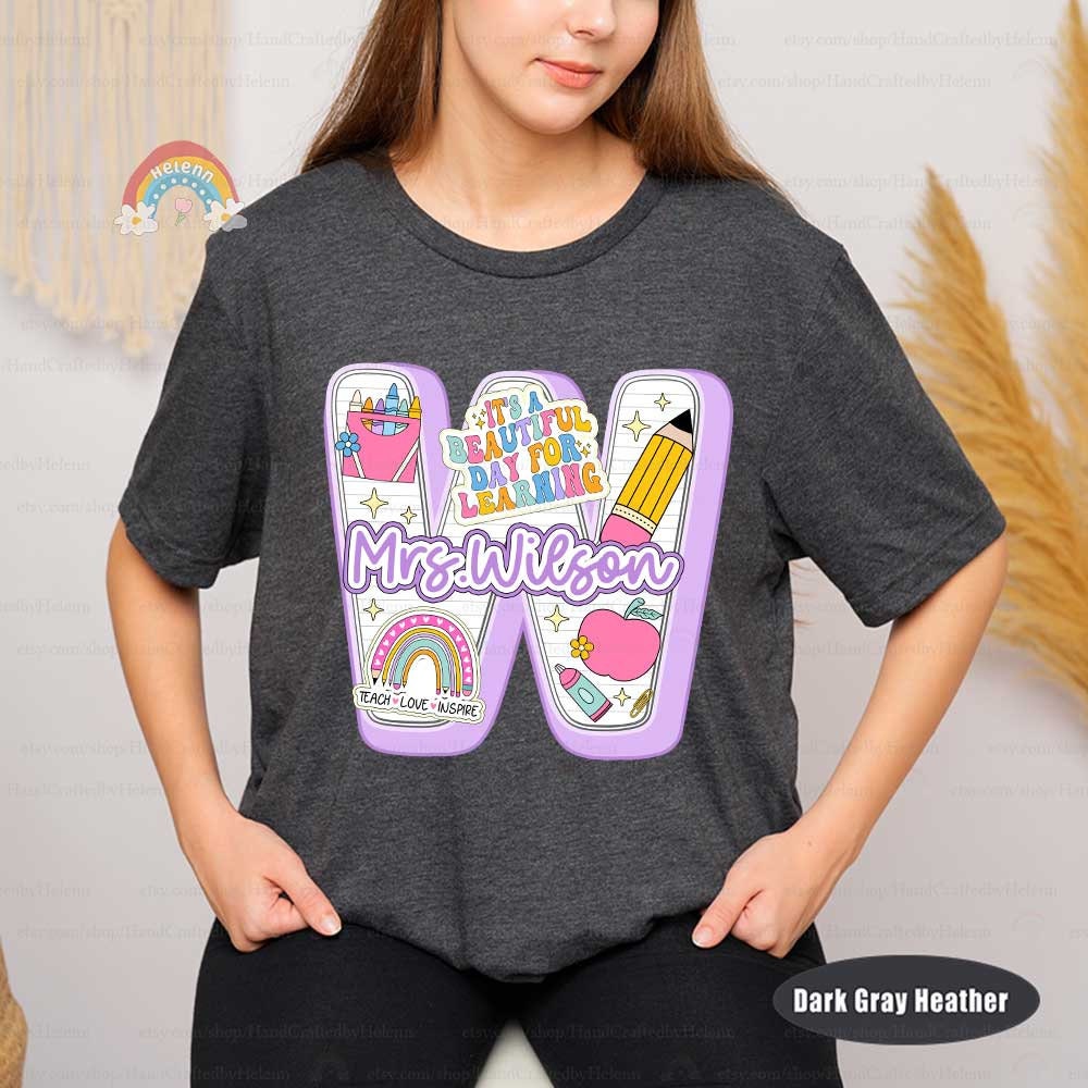 A charming design featuring the phrase It&#39;s a beautiful day for learning in playful lettering around a flowing ribbon, complemented by a cheerful array of educational icons like a pencil, apple, and rainbow.