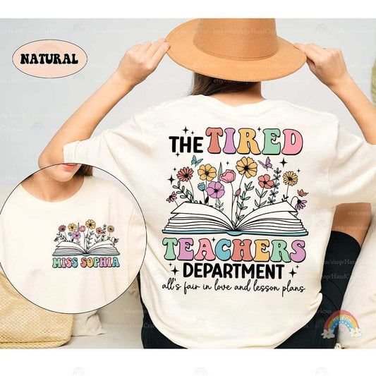 A playful yet expressive design that captures the exhaustion of teaching with TIRED TEACHERS written in bold, colorful letters, underscored by floral and butterfly motifs which add a touch of whimsy and brightness to the theme.