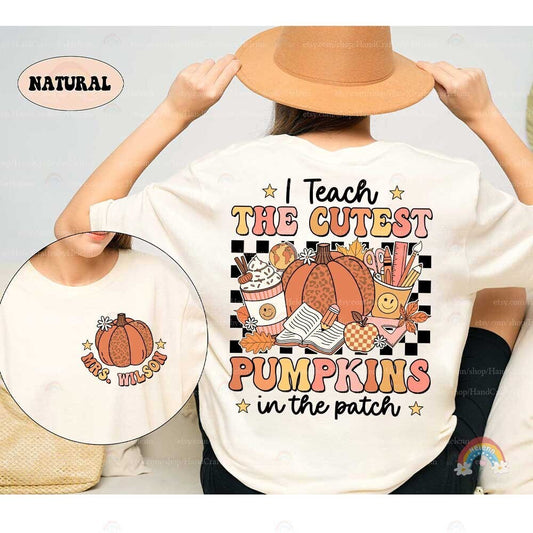 This charming design features a leopard-print pumpkin surrounded by school supplies, fall leaves, and a cozy cup of cocoa, all set against a black background with bold, colorful text.