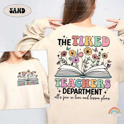 A playful yet expressive design that captures the exhaustion of teaching with TIRED TEACHERS written in bold, colorful letters, underscored by floral and butterfly motifs which add a touch of whimsy and brightness to the theme.