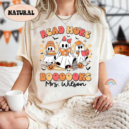 Festive image with three whimsical ghosts reading, surrounded by autumnal elements on a black background with a playful phrase.