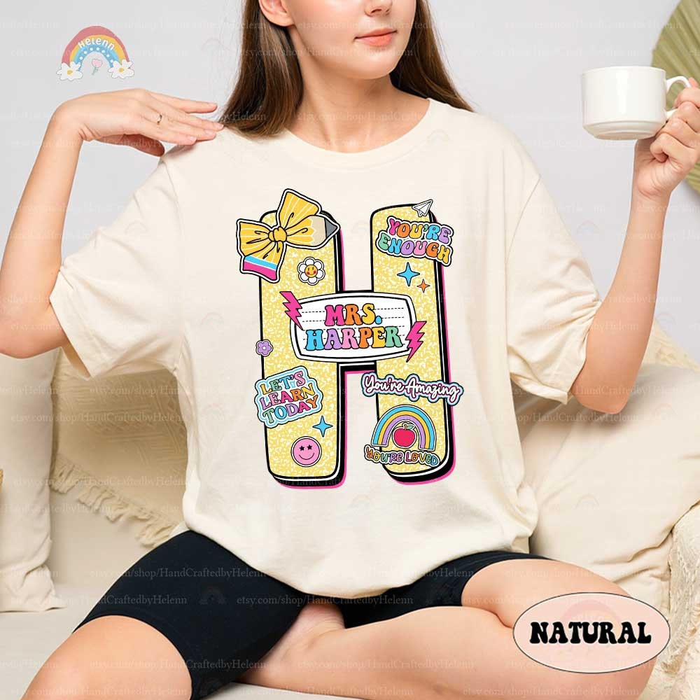 A bright and fun design with large letters representing different colors decorated with cheerful icons like bows and smiley faces Each letter includes the teacher&#39;s name in a playful font