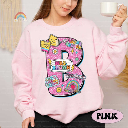 A bright and fun design with large letters representing different colors decorated with cheerful icons like bows and smiley faces Each letter includes the teacher&#39;s name in a playful font