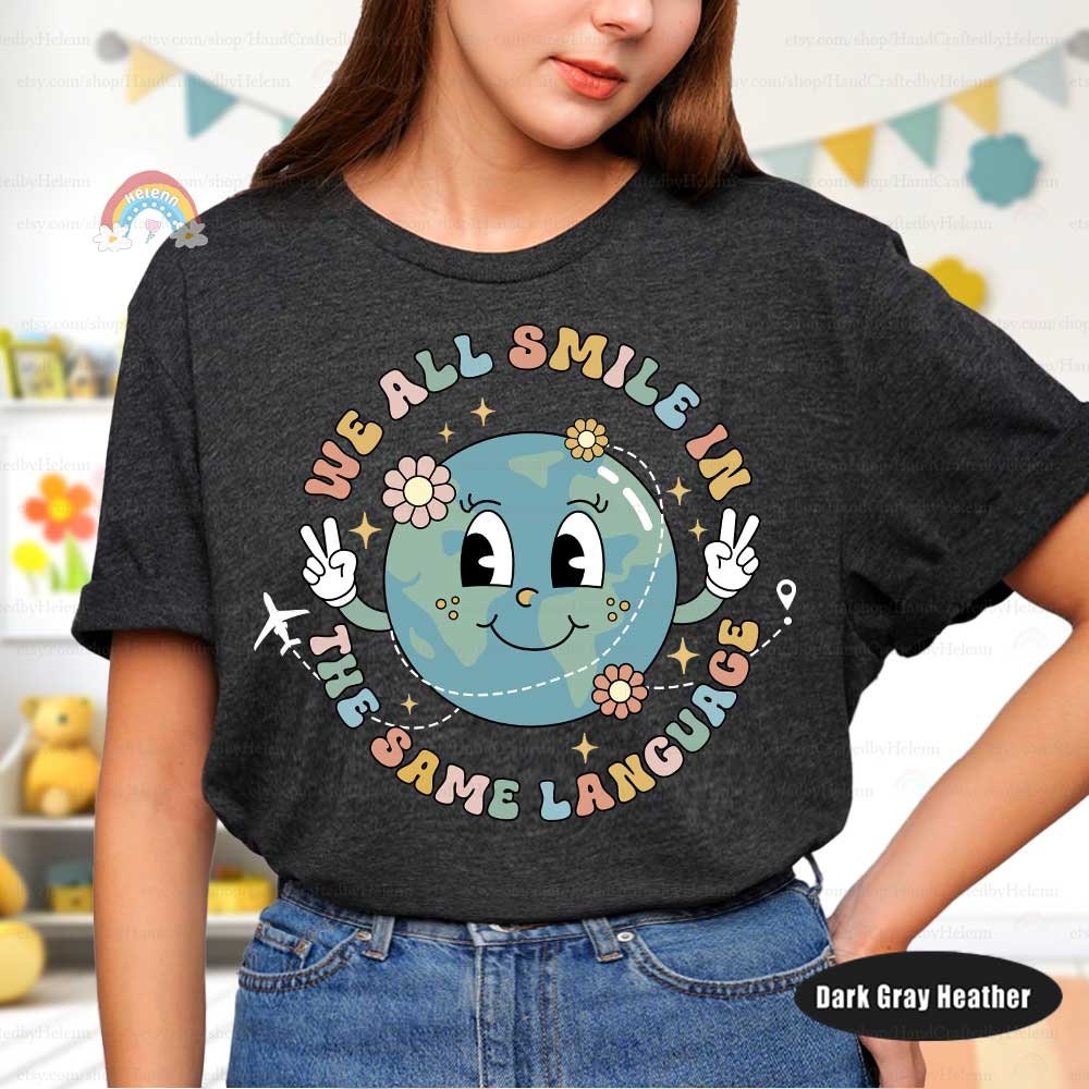 A heartwarming design showcasing a smiling globe with peace signs surrounded by the phrase We all smile in the same language The design is decorated with flowers and a plane representing worldwide friendship and joy