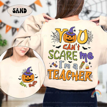 A lively Halloween-themed graphic featuring You can&#39;t scare me I&#39;m a teacher in bold fonts surrounded by festive icons like a jack-o&#39;-lantern with a witch hat spider webs bats and candy making it perfect for the season