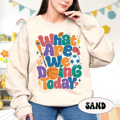 A cheerful sports-themed design with the phrase What are we doing today written in colorful playful letters The design includes icons like a basketball soccer ball baseball bat and football adding a dynamic and fun atmosphere