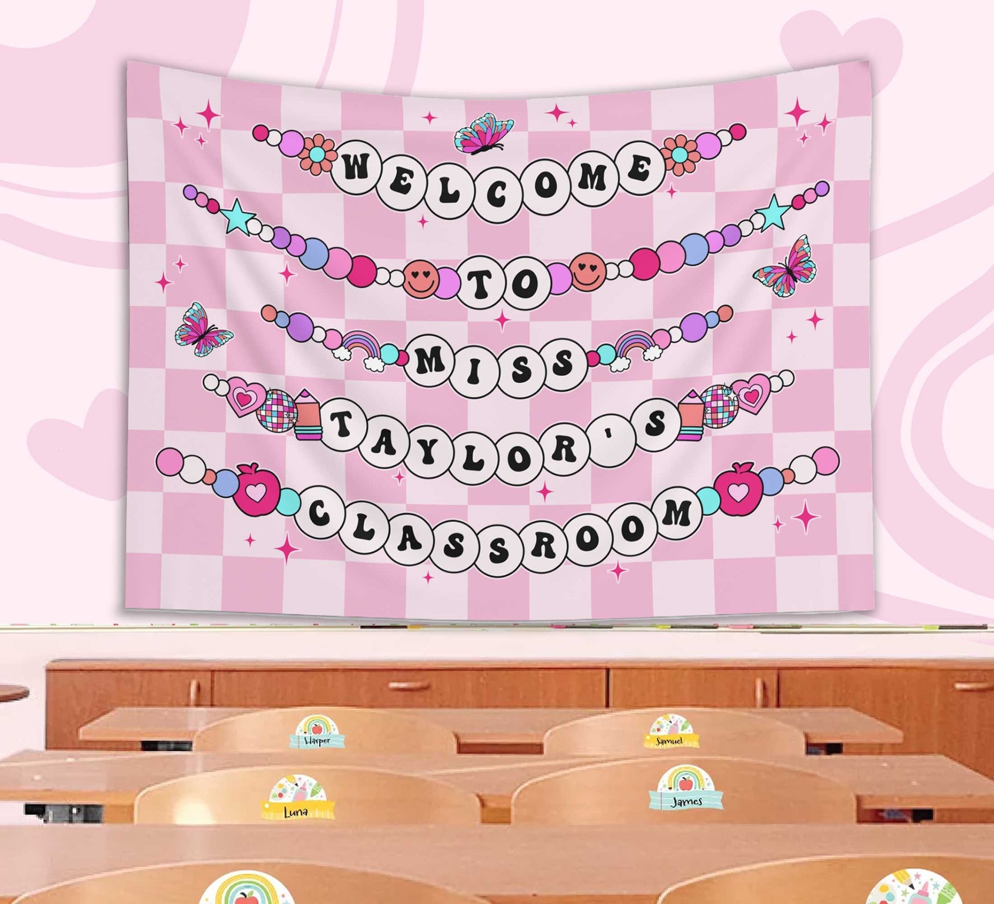 A playful classroom banner displaying Welcome to Miss Taylor&#39;s Classroom in beaded-style letters with butterflies, hearts, and stars on a pink checkered backdrop.