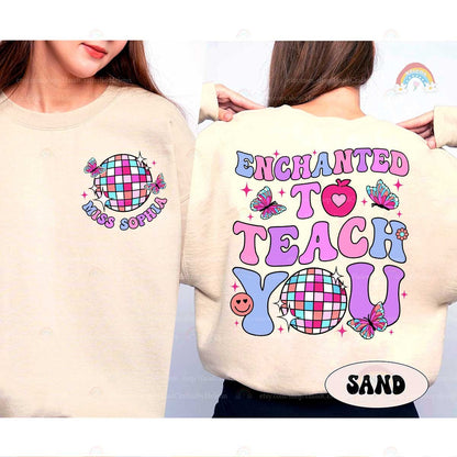A whimsical shirt design with Enchanted to Teach You in bold, vibrant fonts, decorated with butterflies, a heart apple, and a checkered disco ball, creating an enchanting look.