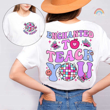 A whimsical shirt design with Enchanted to Teach You in bold, vibrant fonts, decorated with butterflies, a heart apple, and a checkered disco ball, creating an enchanting look.
