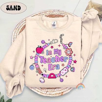Colorful and cute, this T-shirt design with In My Teacher Era surrounded by a playful beaded bracelet and whimsical charms captures the essence of a joyful teaching journey.