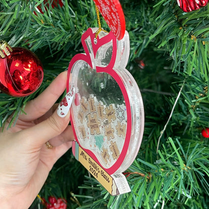 This charming teacher ornament is designed as a red apple with personalized puzzle pieces displaying student names, centered around Mrs. Smith. The shakeable snow and festive details make it a perfect gift for the holidays.