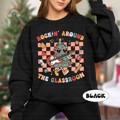 This festive and energetic T-shirt design shows a groovy Christmas tree with an electric guitar, surrounded by gifts and classroom items. The phrase Rockin&#39; Around the Classroom makes it a perfect blend of holiday cheer and education.