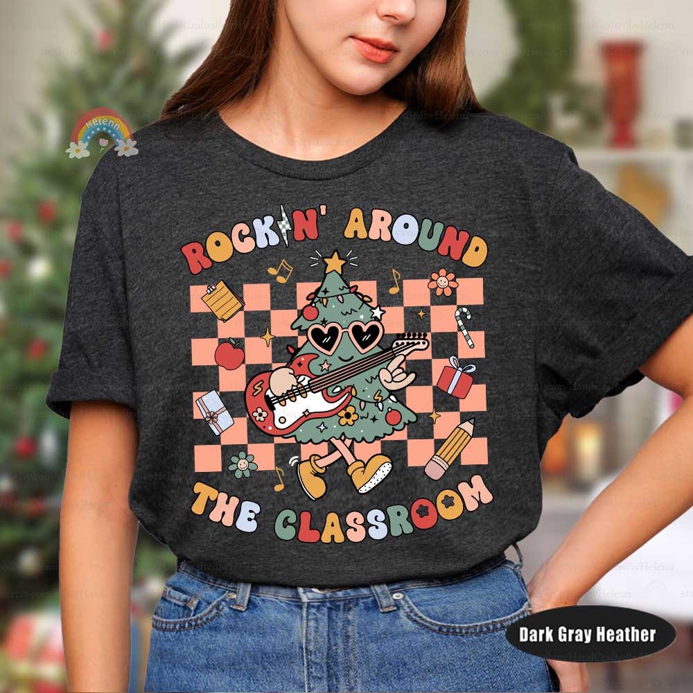 Whimsical T-shirt featuring a guitar-playing Christmas tree with classroom-related items such as apples, gifts, and pencils. The bright colors and playful design are perfect for celebrating the holiday season in a fun way.