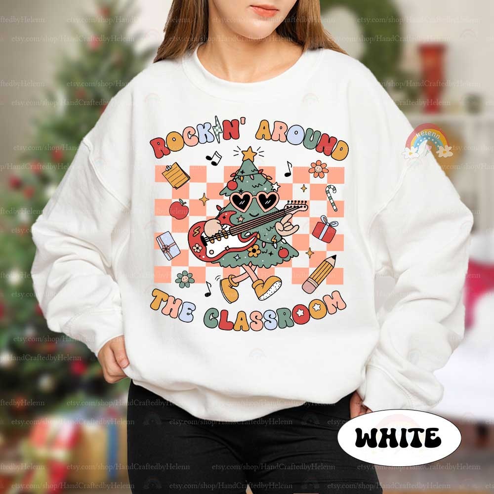 This festive and energetic T-shirt design shows a groovy Christmas tree with an electric guitar, surrounded by gifts and classroom items. The phrase Rockin&#39; Around the Classroom makes it a perfect blend of holiday cheer and education.