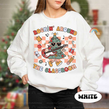 This festive and energetic T-shirt design shows a groovy Christmas tree with an electric guitar, surrounded by gifts and classroom items. The phrase Rockin&#39; Around the Classroom makes it a perfect blend of holiday cheer and education.