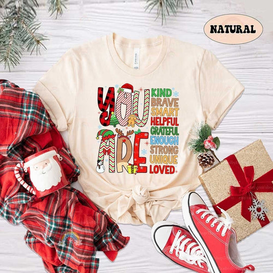 Bright and festive design featuring bold, decorated letters spelling You Are, followed by positive affirmations like Kind, Brave, Smart, and Loved. Perfect for spreading holiday cheer with an uplifting message.