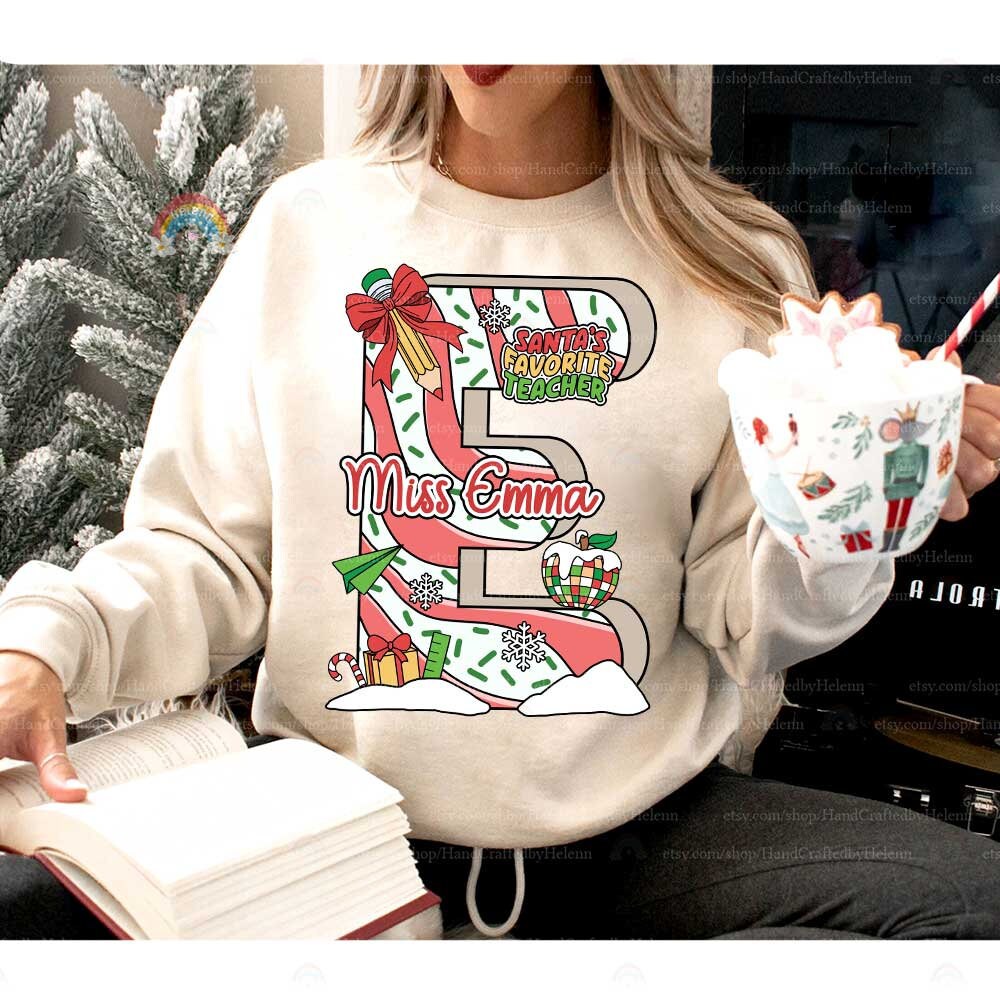 Playful and bright T-shirt design featuring a customized letter filled with Christmas decorations, from bells to wrapped gifts. The addition of the teacher&#39;s name, like Miss Brown, creates a fun and personalized holiday look.