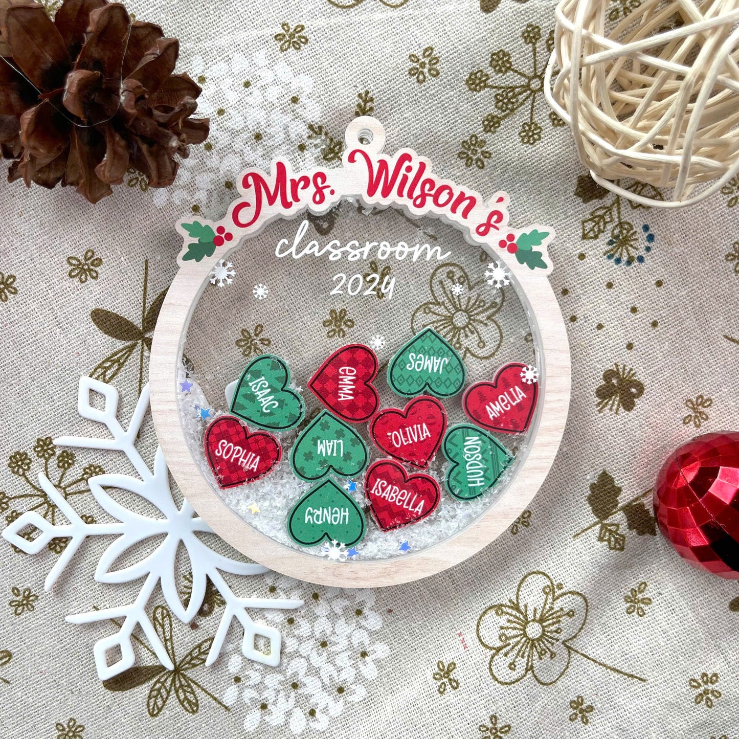 Charming holiday ornament displaying Mrs. Wilson’s classroom with student names in festive red and green hearts. Perfect for celebrating the 2024 class.