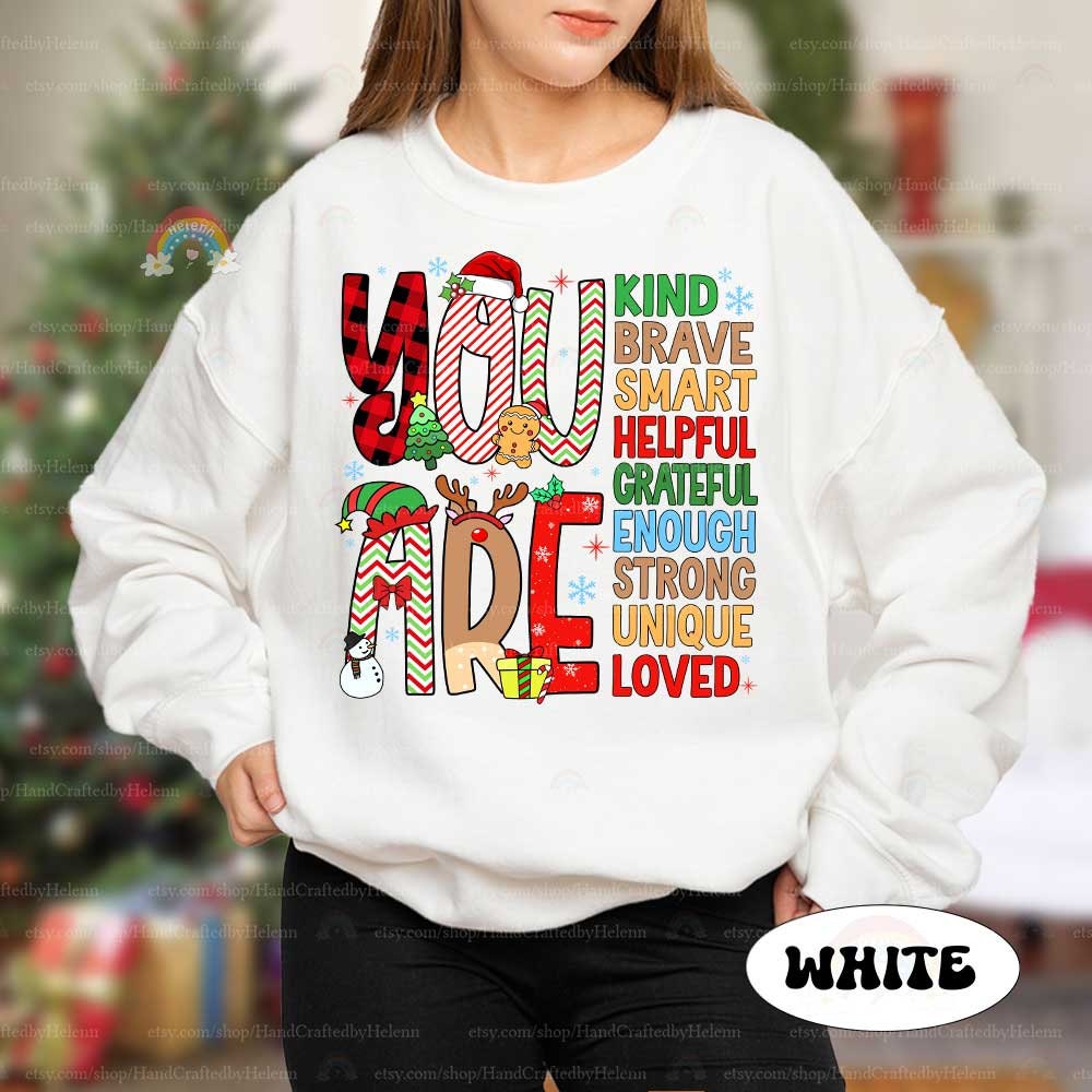 Fun and colorful T-shirt featuring decorated letters and a list of affirmations that remind everyone they are Grateful, Brave, and Loved, adding a special touch to the holiday season.