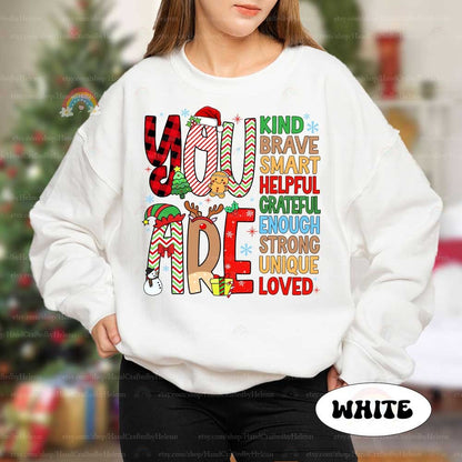 Fun and colorful T-shirt featuring decorated letters and a list of affirmations that remind everyone they are Grateful, Brave, and Loved, adding a special touch to the holiday season.