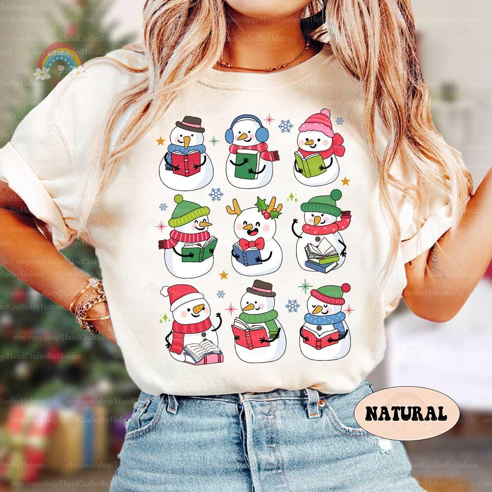 Cozy snowmen with books, each with unique winter attire, making this a perfect holiday shirt for any reading enthusiast.