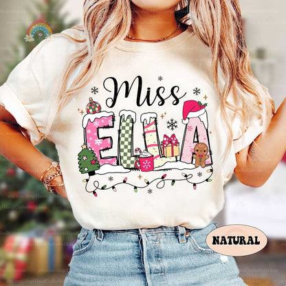 Festive and fun sweatshirt featuring the name Miss Ella decorated with holiday-themed elements like a Christmas tree, hot cocoa, gifts, and a gingerbread man. Perfect for spreading holiday cheer in the classroom.