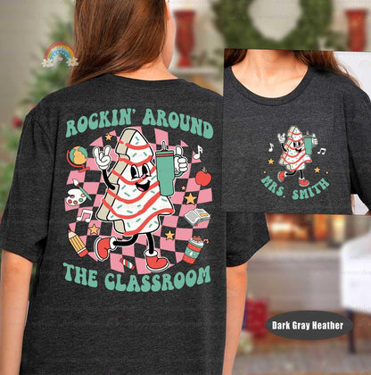 Fun Christmas tree character dancing alongside classroom icons, making this shirt a festive choice for teachers during the holiday season.